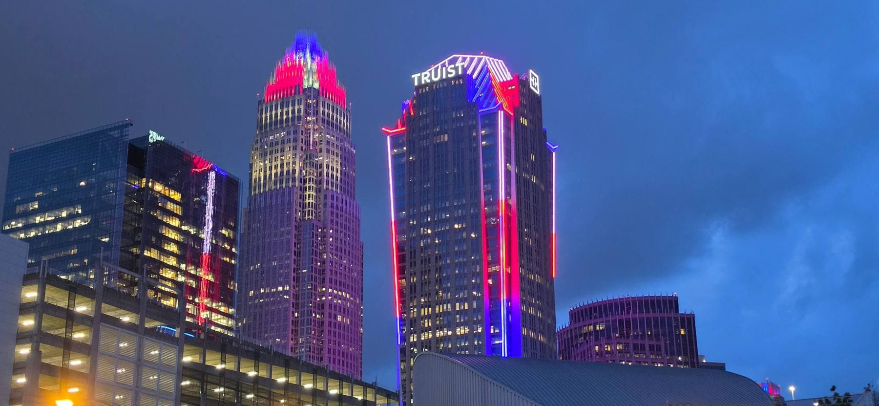 Charlotte skyline illuminated in red, white, and blue at dusk