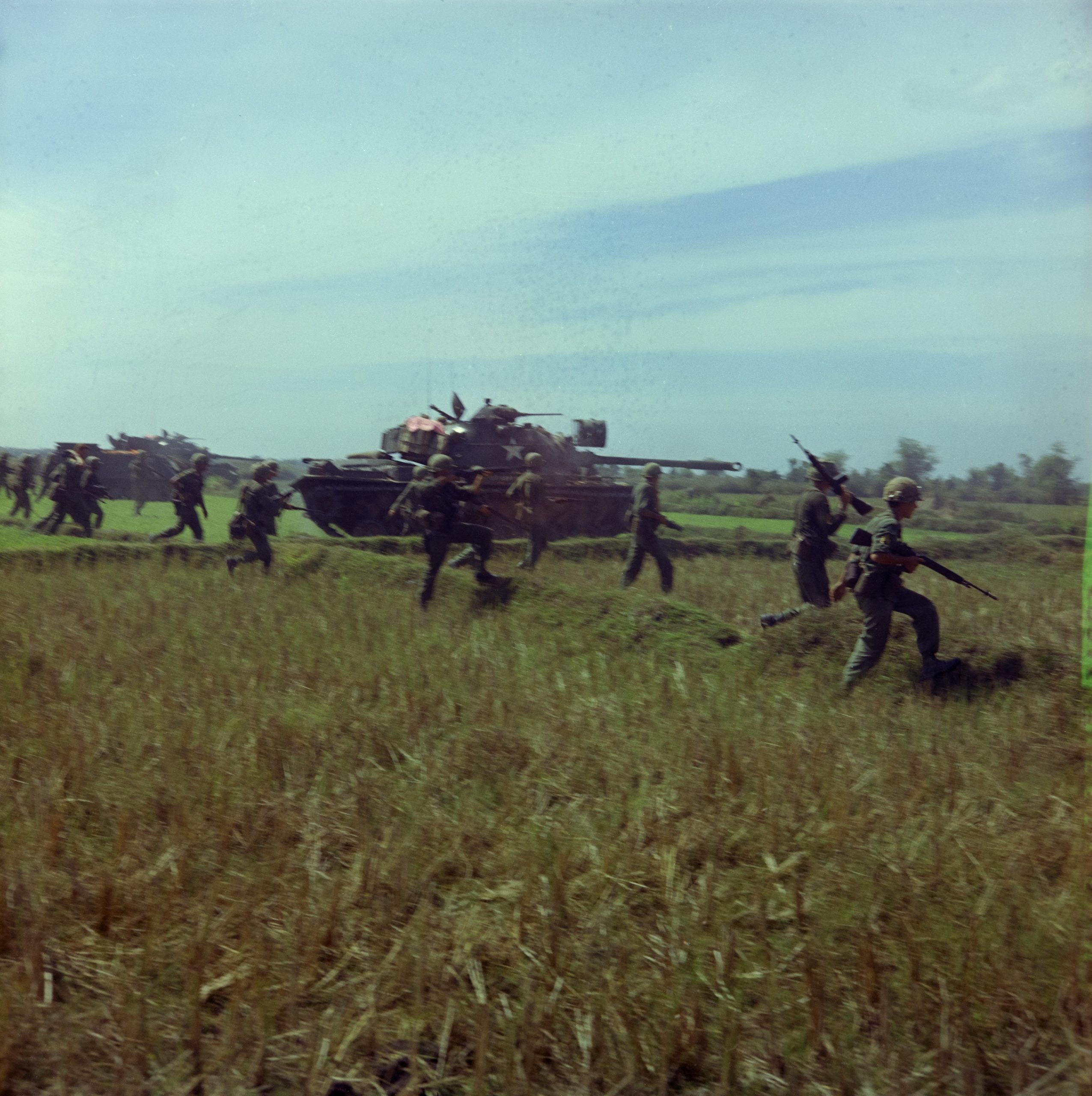 U.S. troops moving through a field beside an M48 tank near Lai Khê, Vietnam, in January 1966